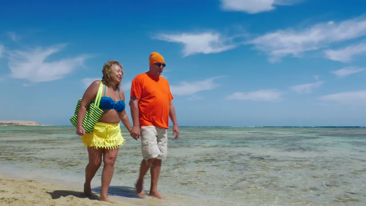An older couple walking together on a beach